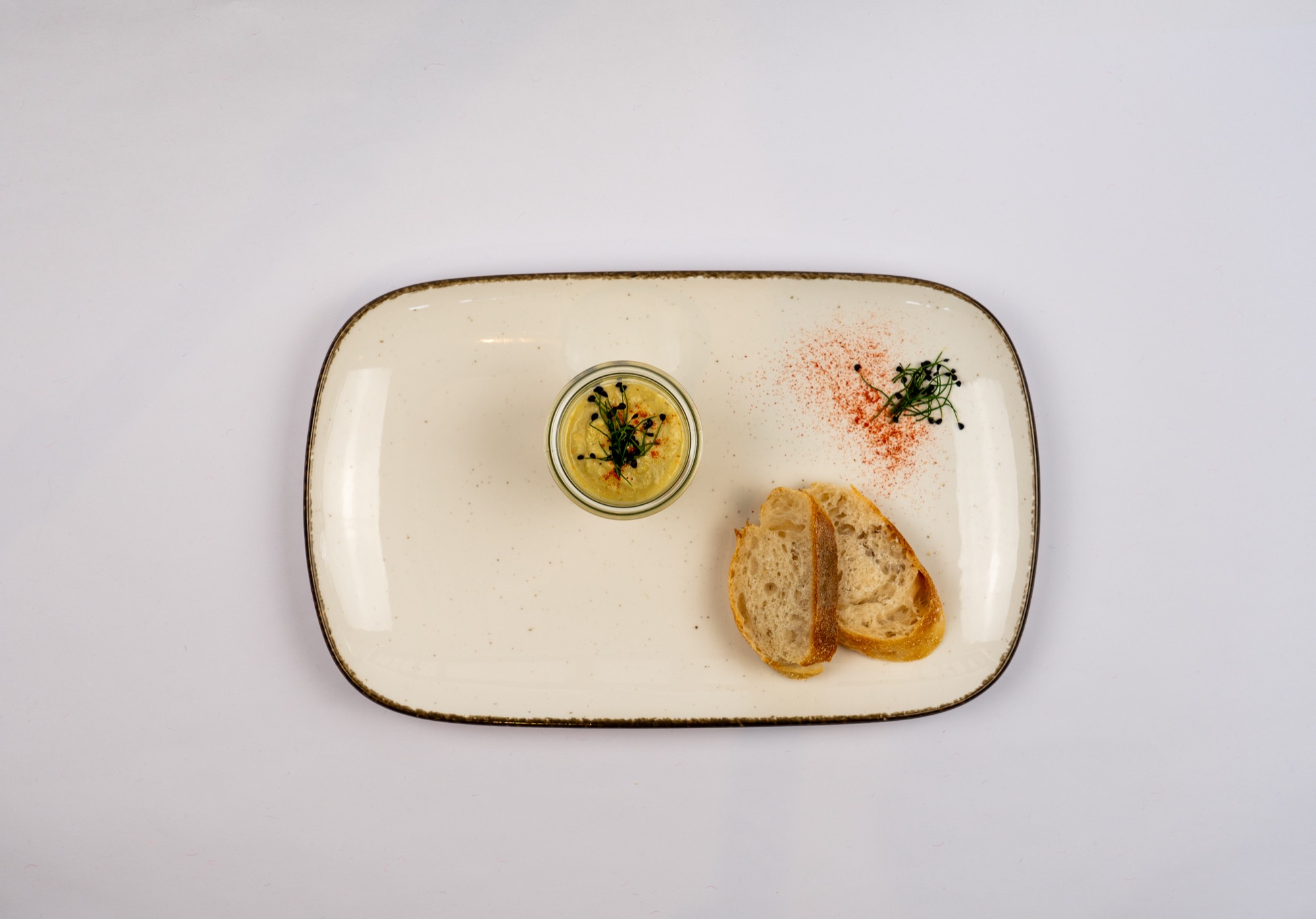 Linsen-Kokossuppe im Glas mit Baguette-Scheiben auf einer Platte