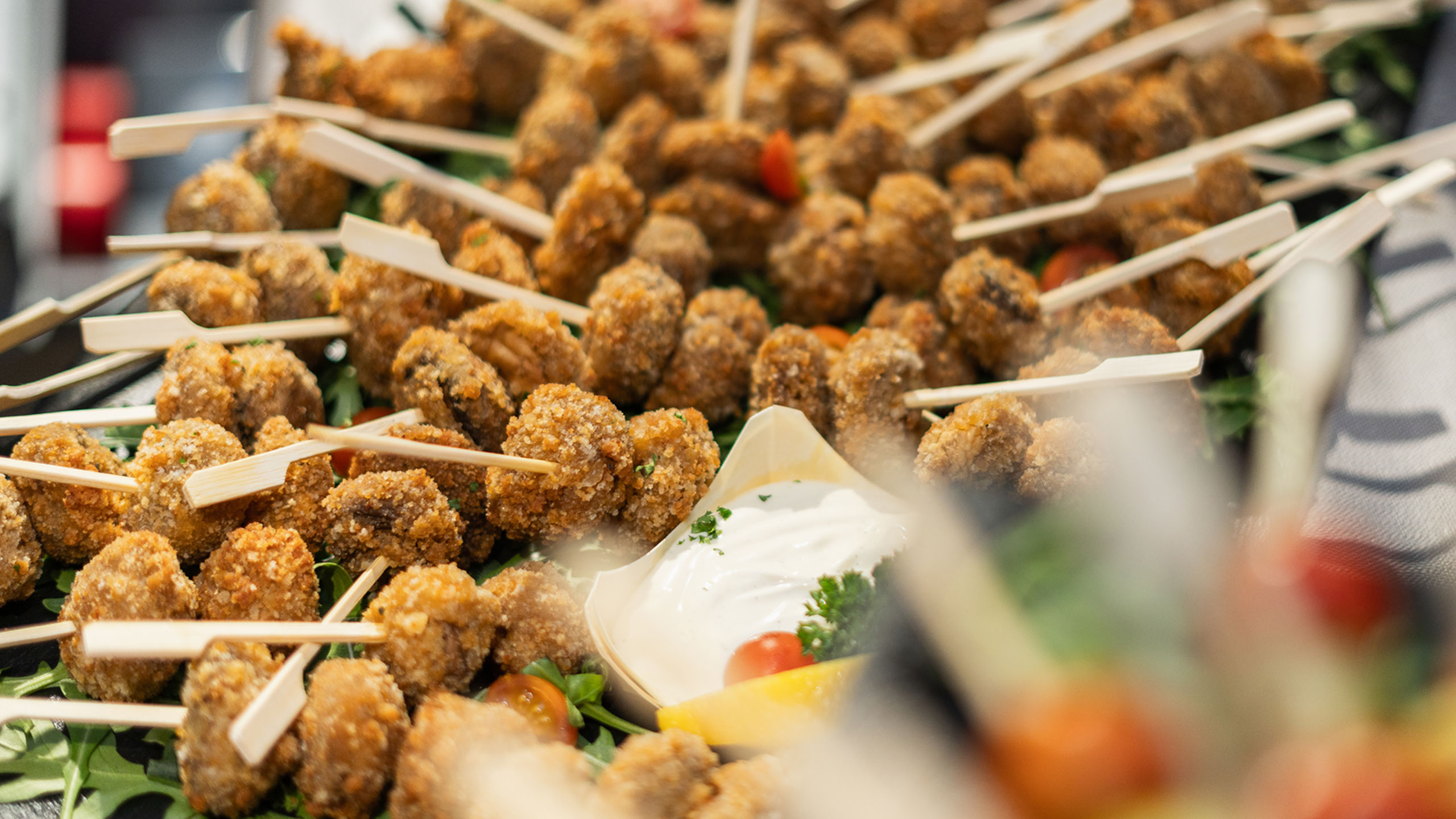 Frittierte Fingerfood-Spieße mit Dip und Zitrone auf einer Platte