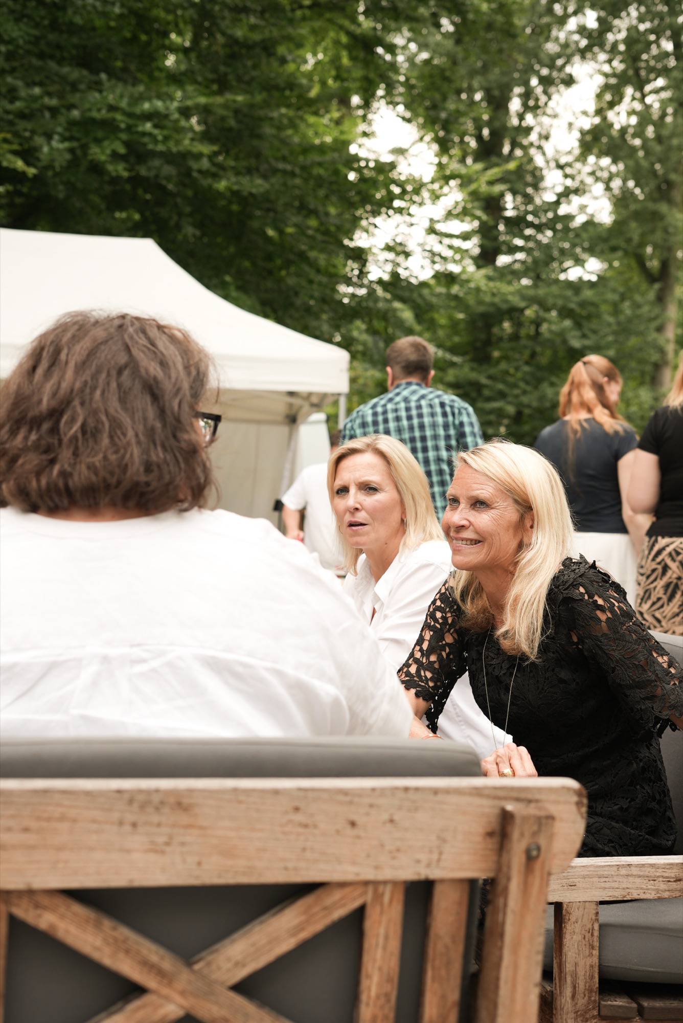 Gäste unterhalten sich im Grünen bei einem Sommerfest